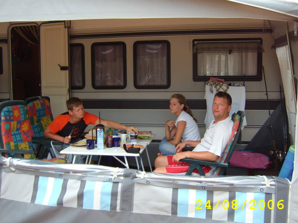 Familie vom Torsten Friedrich (Autor) vor dem Wohnwagen am Frühstückstisch auf der Insel Cres, Kroatien 2006