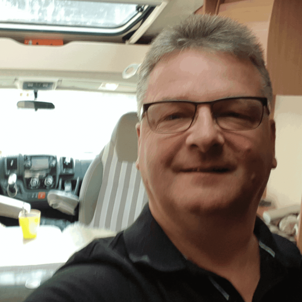 Selfie von Torsten Friedrich (Autor) im Innenraum vom Wohnmobil. Draußen strahlt die Sonne Ende Februar in Spanien.